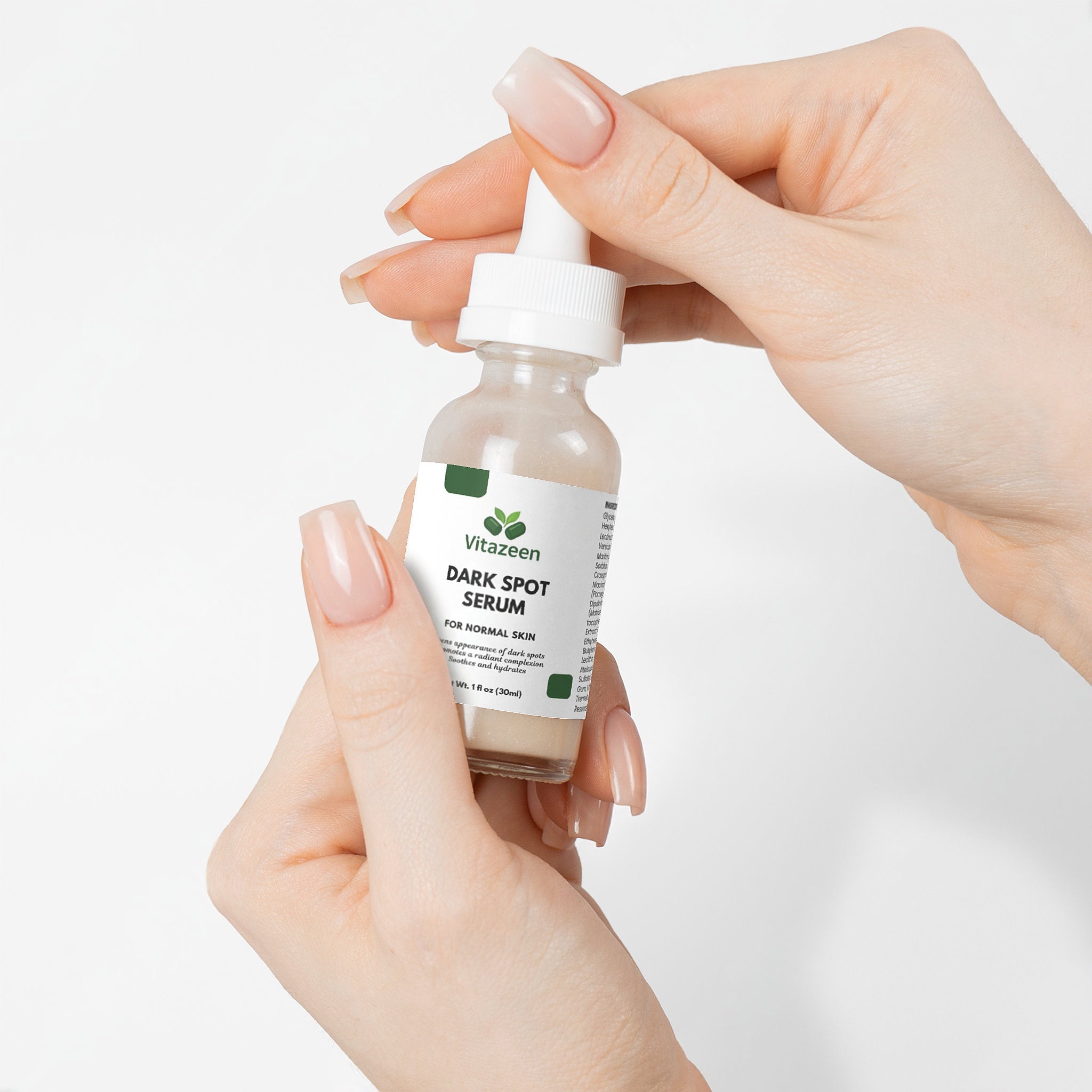 Hand holding a bottle of ViraZeen Dark Spot Serum against a white background
