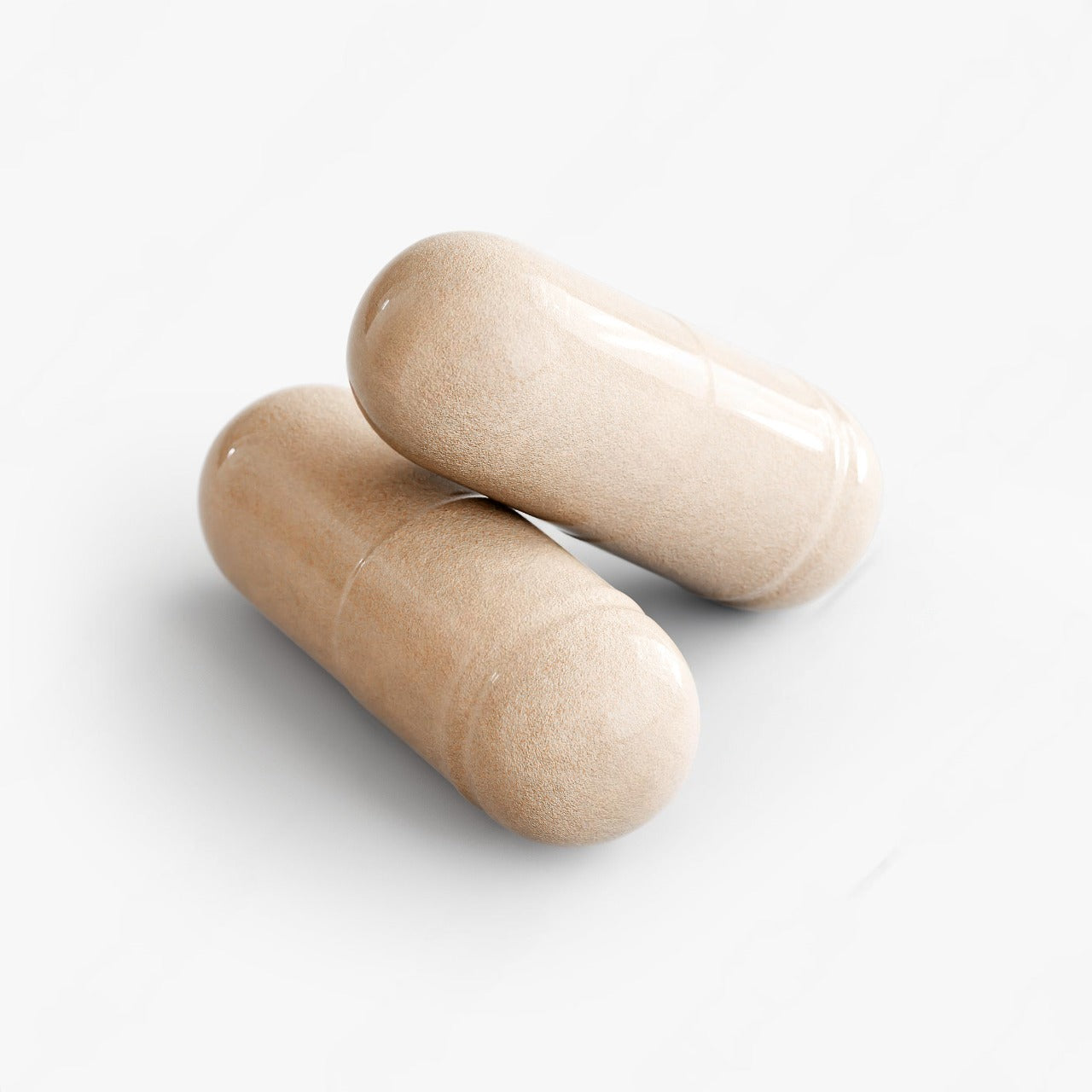Two beige capsules on a white background