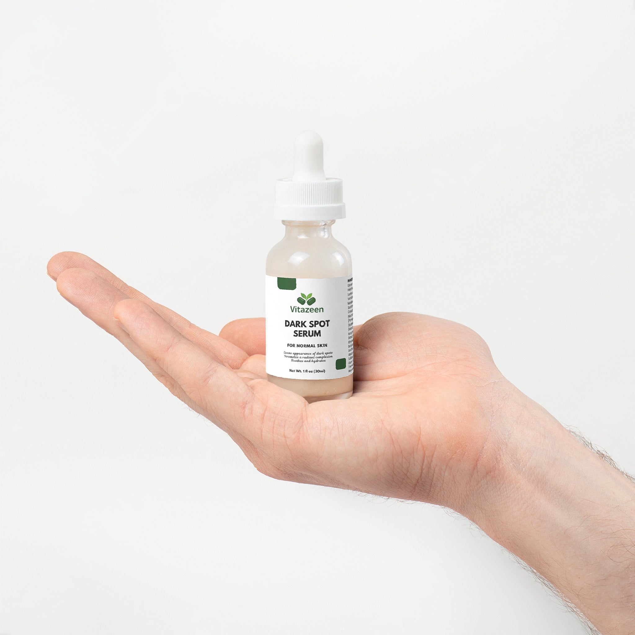 Hand holding a bottle of Vitanzen Dark Spot Serum against a white background