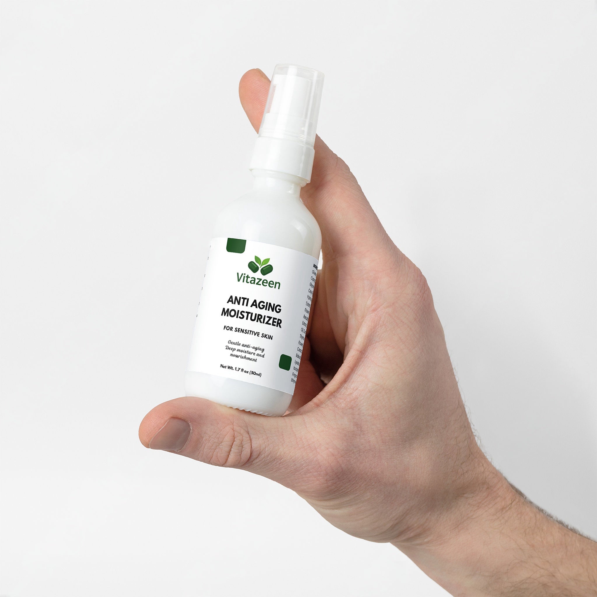 Hand holding a bottle of Vitazeen anti-aging moisturizer against a white background
